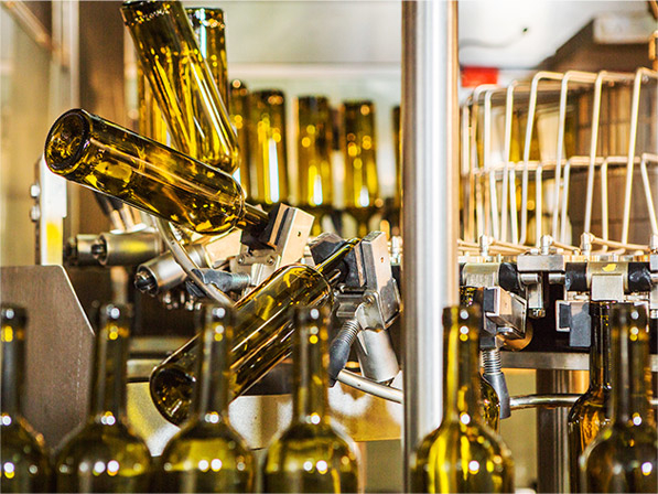 Yellow glass bottles on factory machine